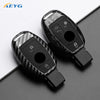 A black slim carbon fiber car key cover with electronic features shown on a dark surface.