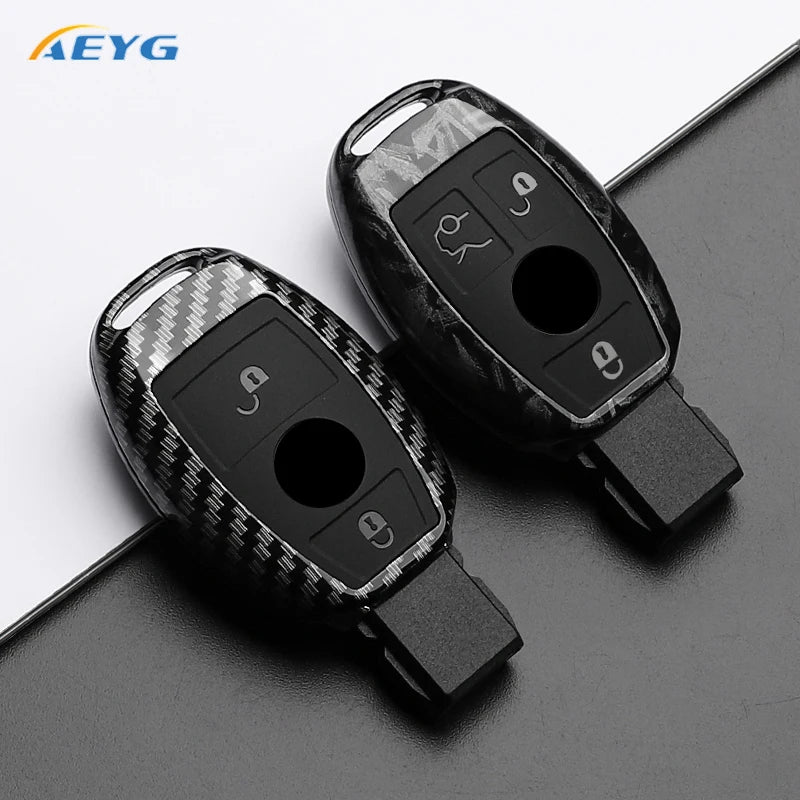 A black slim carbon fiber car key cover with electronic features shown on a dark surface.