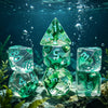 A collection of seven fresh green polyhedral gaming dice floating underwater near marine plants.