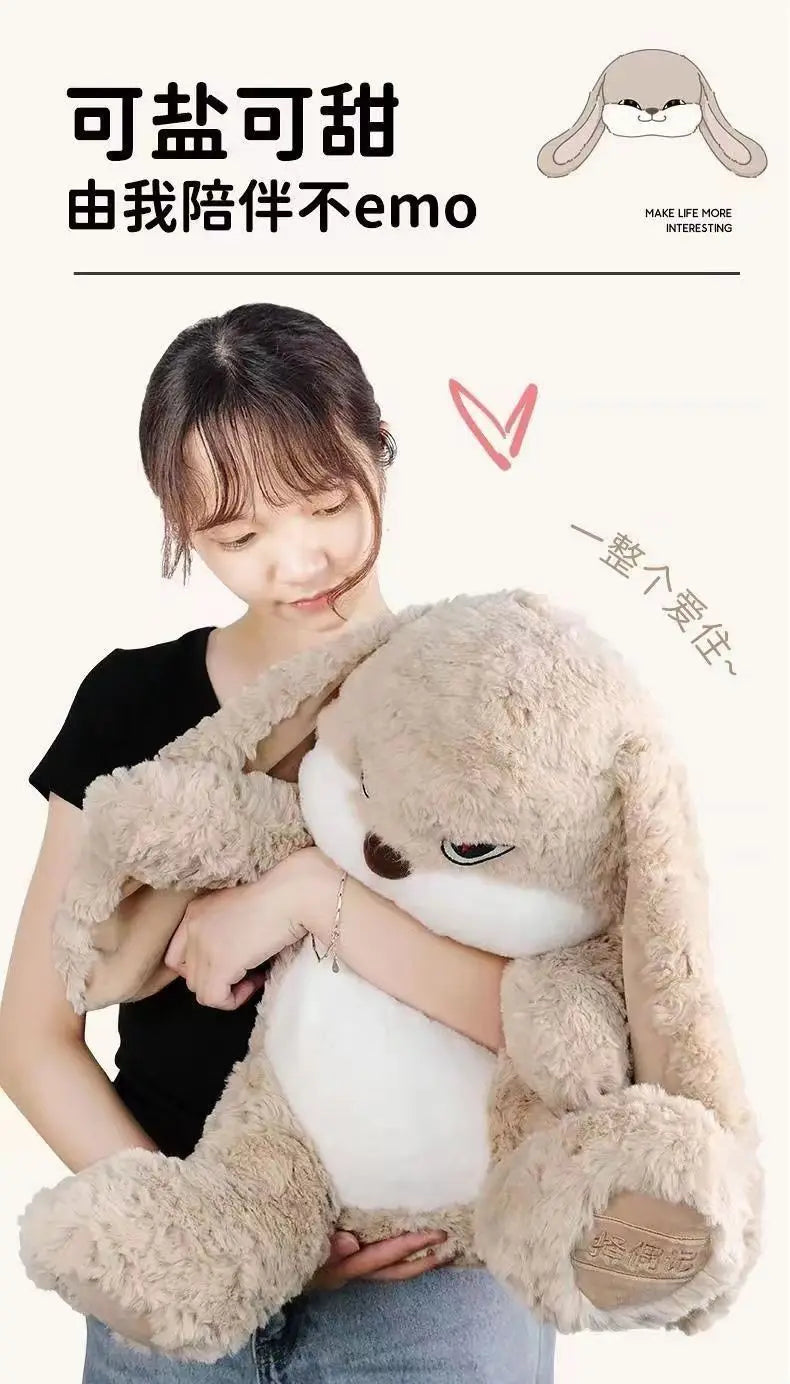 A person is hugging a large, light brown, long-eared rabbit plush toy.