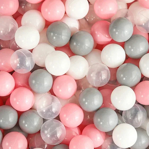 A close-up view of a large pack of colorful plastic ball pit balls in pink, white, and gray.