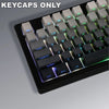 A close-up view of a black mechanical keyboard featuring a set of light gray keycaps with gradient colors.