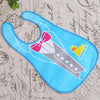 A bright blue wipeable baby bib with a pink bow and a yellow bird design.