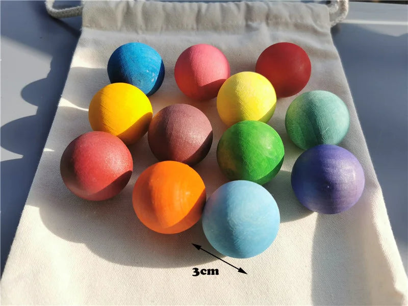 Eine Sammlung farbiger Holzblüten und Murmeln auf einem weißen Tuch mit einem 3cm-Maßstabmarker.