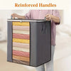 A person is holding an extra large foldable storage bag with reinforced handles, showing its striped interior and dark gray e