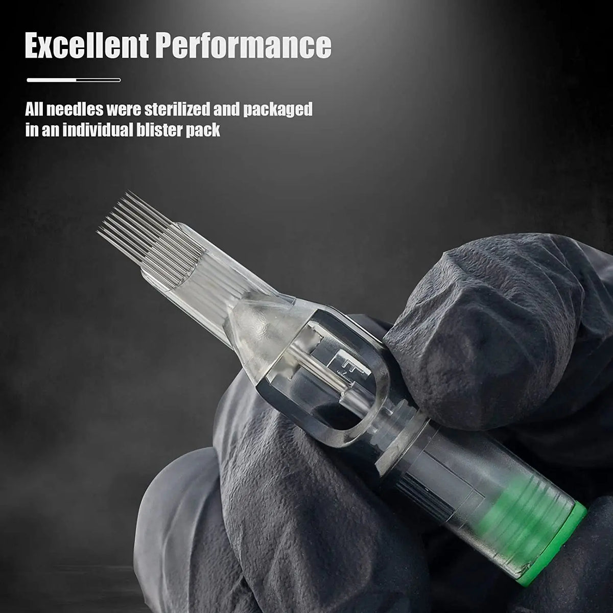 A gloved hand holds a clear tattoo cartridge needle with a green tip and fine wires.