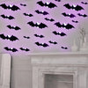 Wall décor featuring glowing black bat silhouettes on a white wall.
