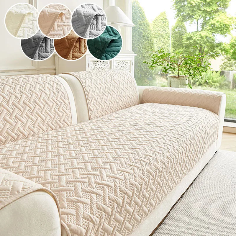 A beige quilted anti-slip sofa cushion displayed on a light-colored sofa with decorative fabric swatches.