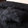 Black quilted bedding set featuring a comforter and pillowcases.