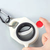 A hand is pressing a white plastic cable tie with a black ring to open it, demonstrating the product for cord management.