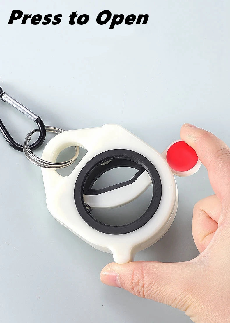 A hand is pressing a white plastic cable tie with a black ring to open it, demonstrating the product for cord management.