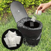 A black portable toilet with absorbent powder packets is shown in a grassy outdoor setting.