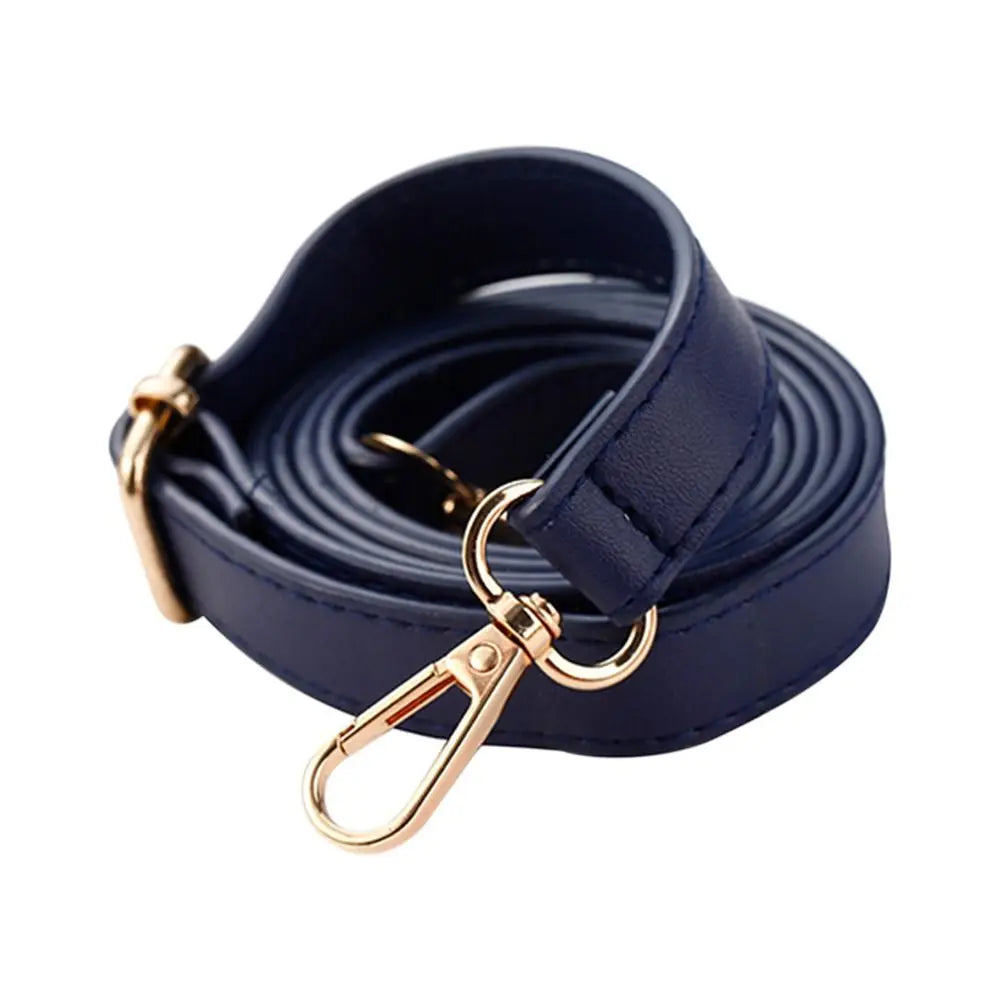 A dark navy blue adjustable leather bag strap replacement coiled and featuring a gold-toned clasp.