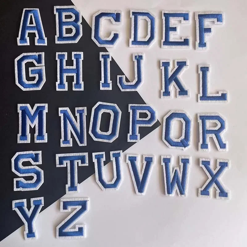 A set of embroidered alphabet patches featuring uppercase letters from A to Z in blue and white thread.