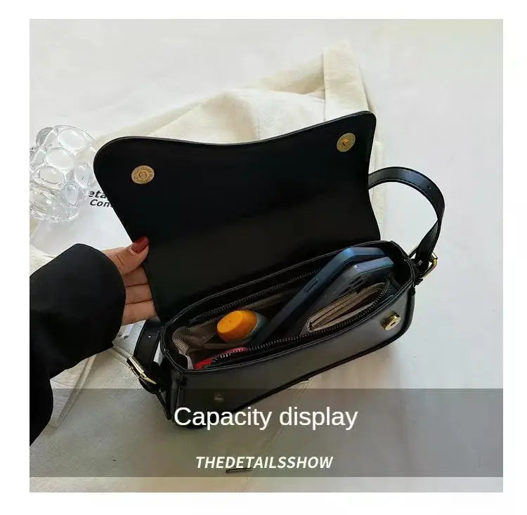 A black vintage leather crossbody bag with a flap closure is displayed against a white background.