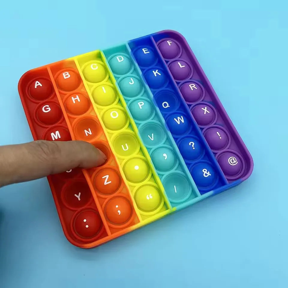 A colorful fidget toy featuring alphabet and number letters in silicone bubbles arranged in a tray