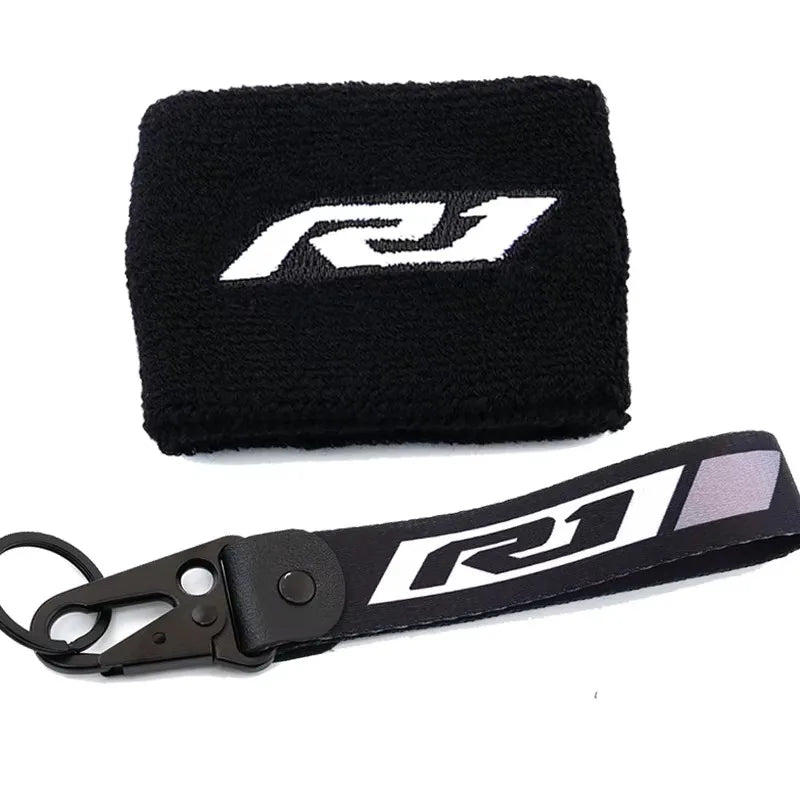 Black neoprene sock with a white R1 logo and a black strap for a brake fluid reservoir cover.