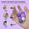 Hand holding purple and white magnetic silicone sensory balls designed for stress relief and focus.