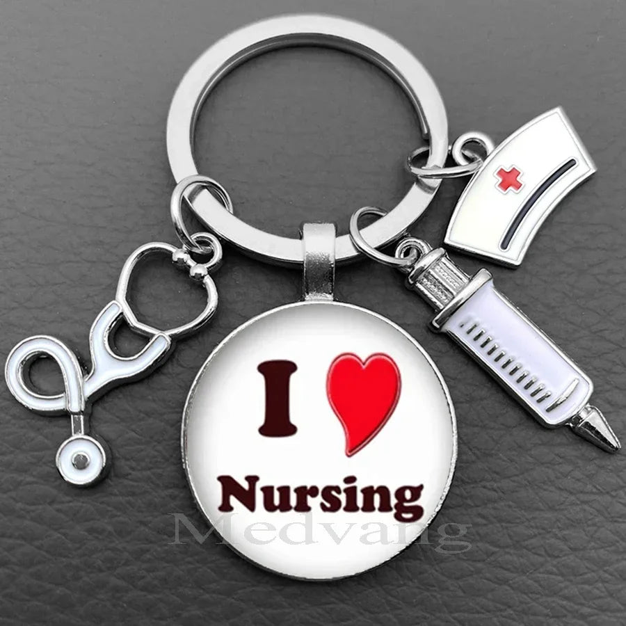 Silver necklace keychain featuring a glass dome charm with the text I Love Nursing and a medical syringe charm.
