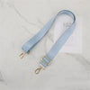 Light blue nylon bag strap with gold buckle displayed on a white card.