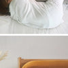 A white linen pillowcase is shown being used in a bedroom setting.