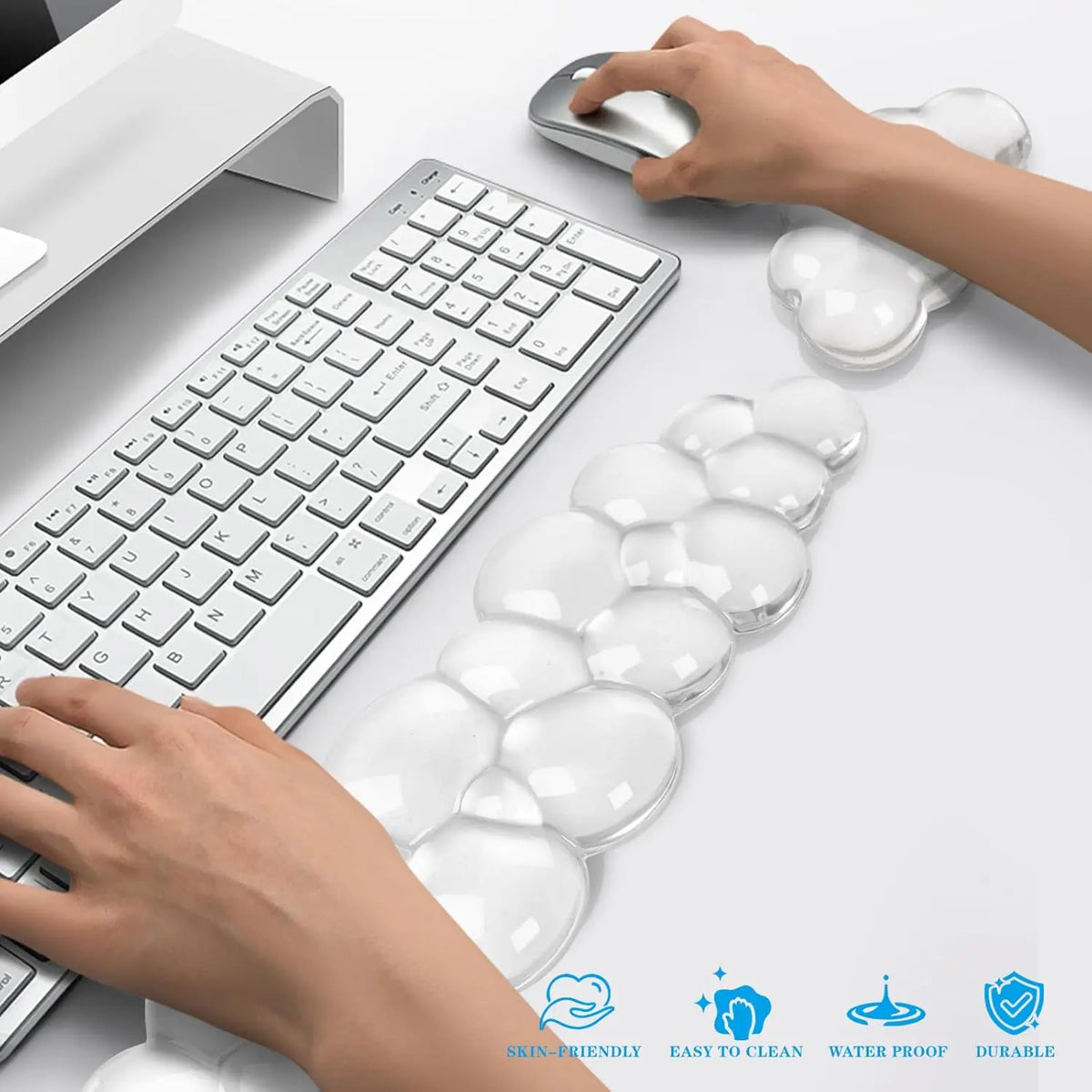 A set of clear cloud-shaped ergonomic wrist rests for a keyboard and mouse are shown next to a laptop and keyboard.