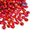A pile of various sized, faceted red and orange rhinestones for DIY crafts and clothing decoration
