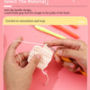 Hands are using a crochet hook to work with white yarn on a pink background.