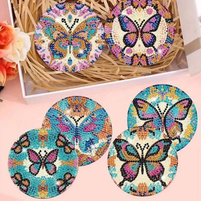 A set of eight ocean-themed diamond art coasters featuring colorful butterfly designs displayed in a natural fiber holder.