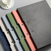 A stack of layered foam boards in various colors, including gray, pink, green, and blue, shown on a light surface.