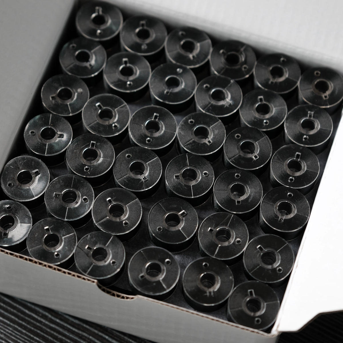 A grid of Class 15 prewound bobbins with 60wt polyester thread for home embroidery machines.