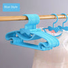 Blue plastic hangers with bow designs hanging from a wooden rod.