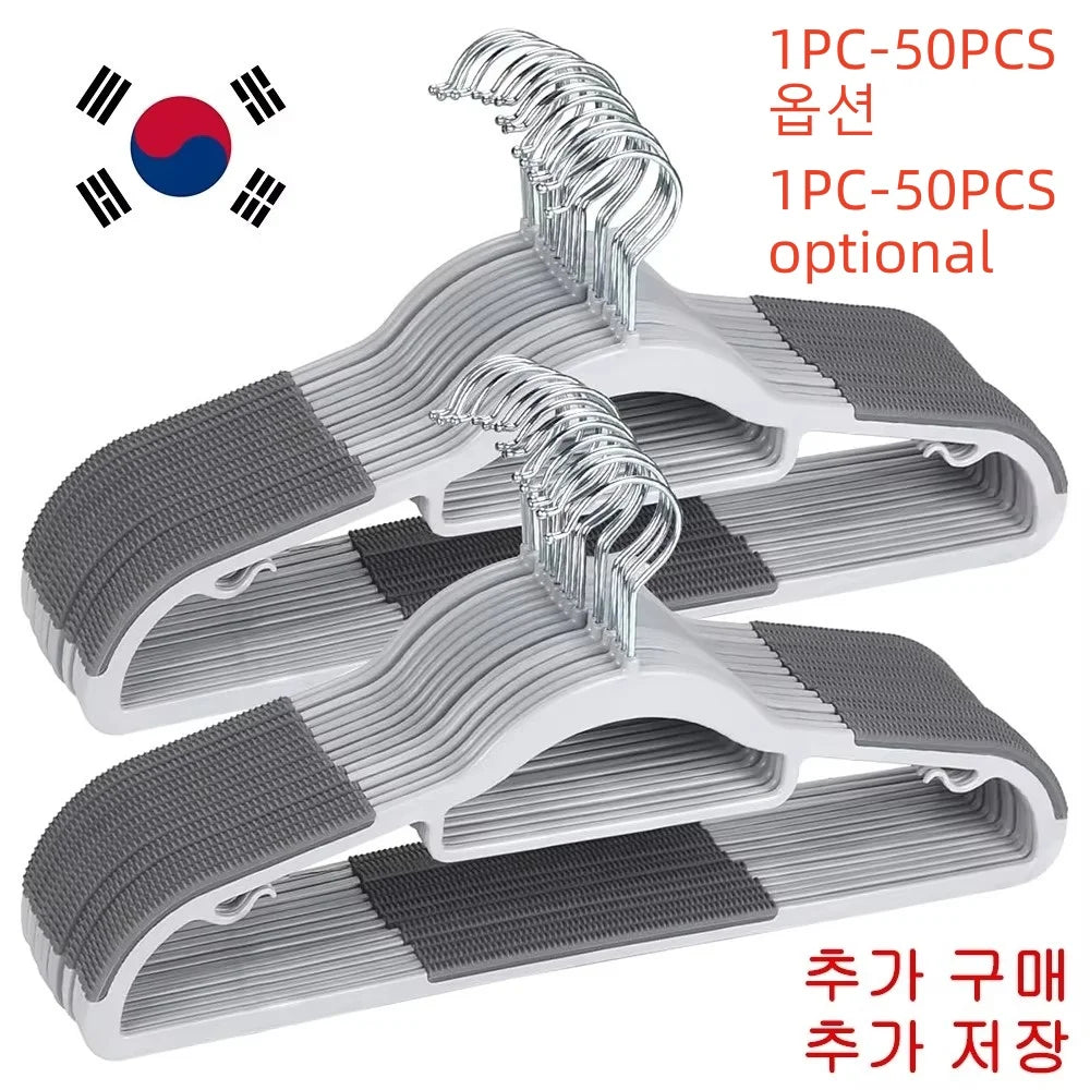 A set of white plastic anti-slip hangers with rotating hooks and gray anti-slip pads.