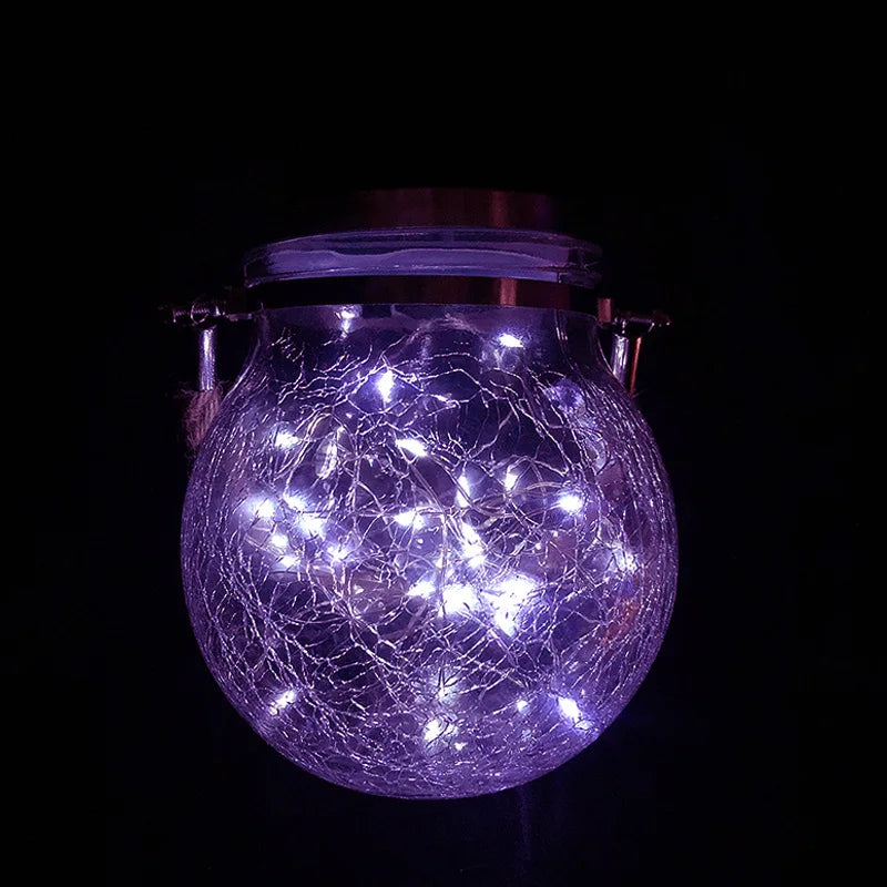 A glowing purple crackle glass solar lantern illuminating a spherical shape against a dark background.