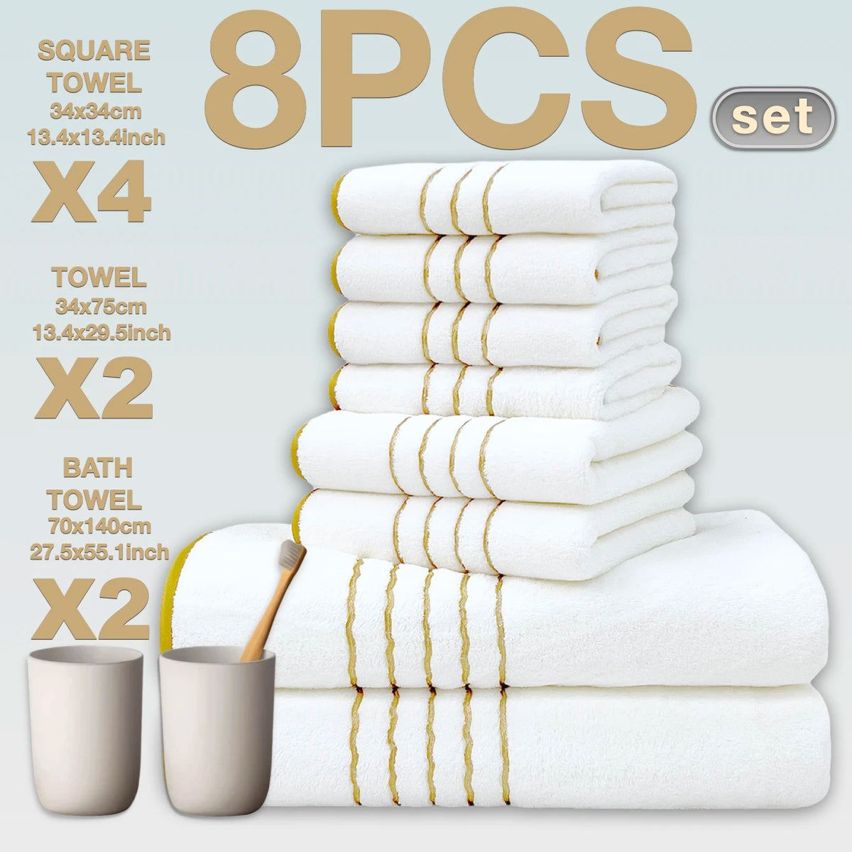 A set of eight white bath towels with gold stripes stacked and displayed next to a wooden brush.