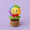 Handcrafted crochet sunflower with colorful petals growing in a brown yarn pot