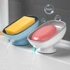 A yellow bar of soap is being dispensed from a blue suction cup soap dish into a white dish.