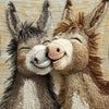 A knitted picture of two adorable donkeys with their faces touching on a beige cushion cover.