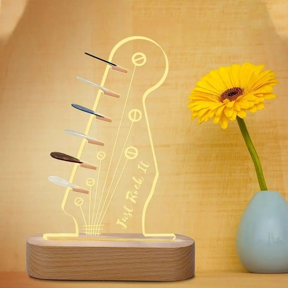 Illuminated acrylic guitar pick holder with a wooden base featuring a guitar silhouette and picks.