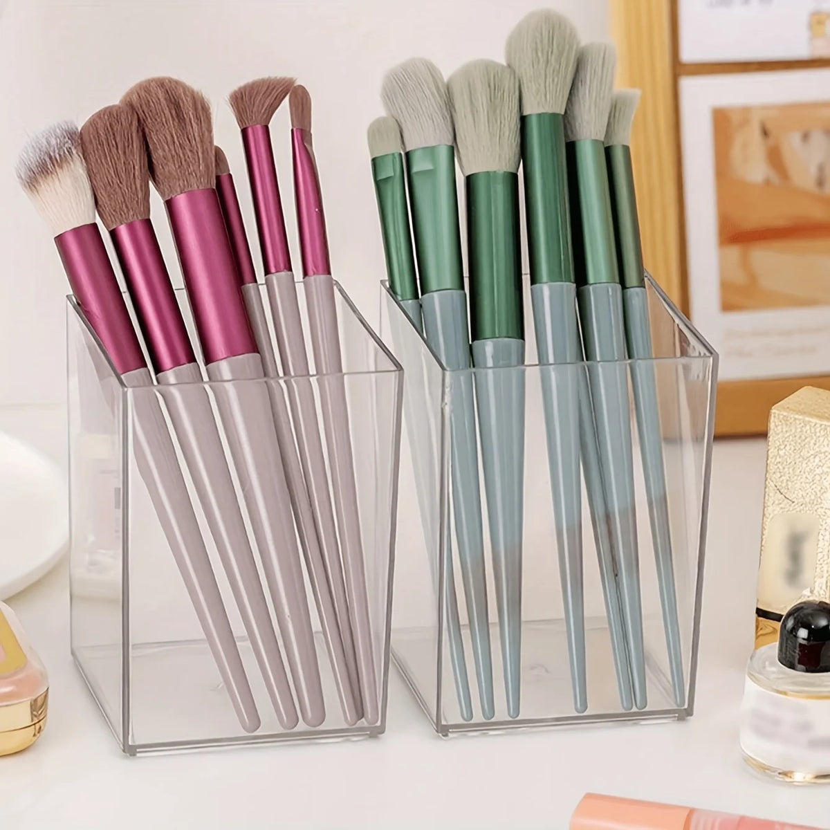 A clear acrylic pen holder filled with various makeup brushes and tools.