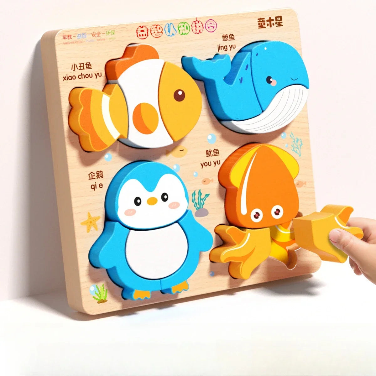 A wooden jigsaw puzzle featuring three colorful animal figures: a yellow fish, a blue seal, and a light blue penguin.