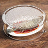 Clear microwave splatter cover with a heat-resistant handle placed over a piece of fish