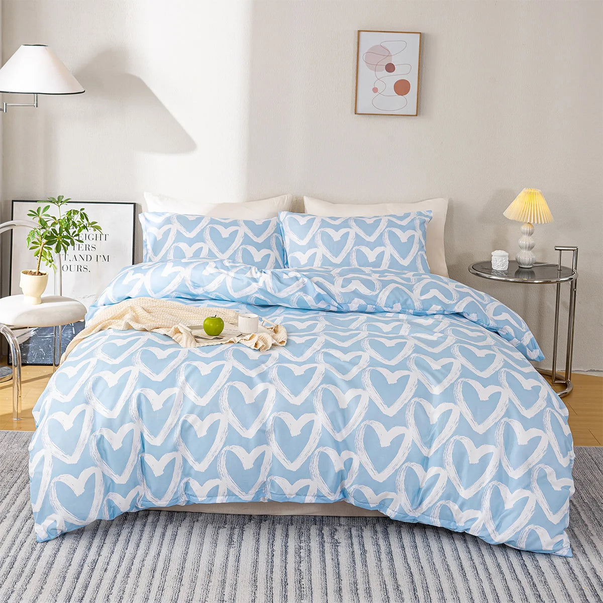 A light blue heart print duvet cover set with white hearts and pillowcases on a bed.