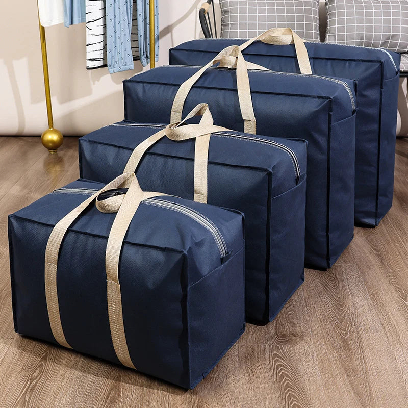 A stack of dark blue waterproof moving and storage bags tied with beige straps on a wooden floor.