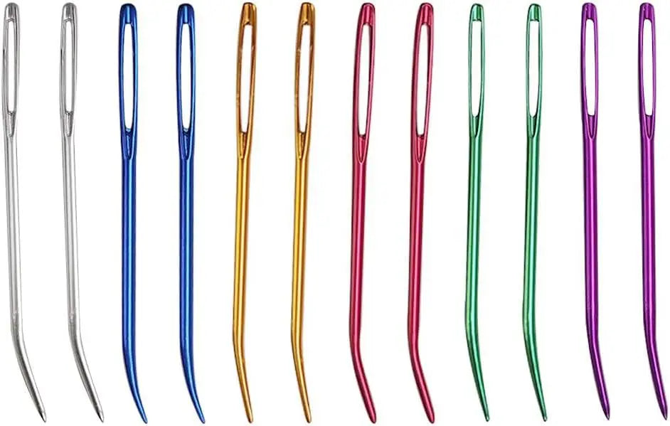 A row of bent tip tapestry needles in various colors including silver, blue, gold, green, pink, and purple.