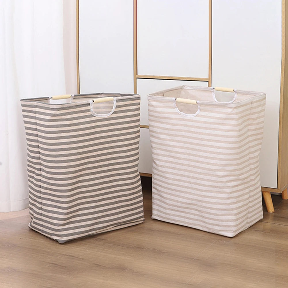 Two foldable waterproof laundry baskets, one striped gray and the other beige, standing on a wooden floor.