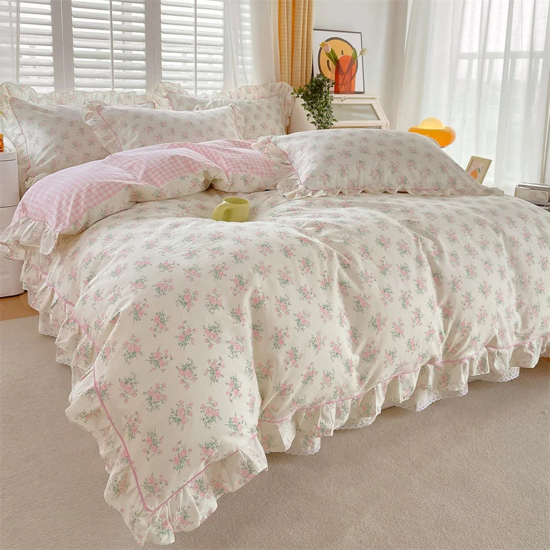 A floral ruffle cotton duvet cover set in soft pink and cream tones displayed on a bed.