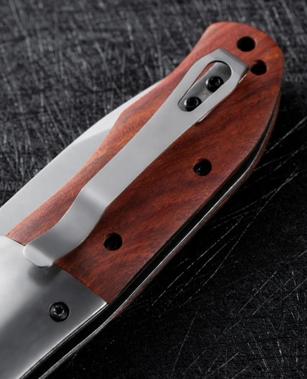A folding pocket knife featuring a dark walnut wood handle and stainless steel blade, shown in profile.