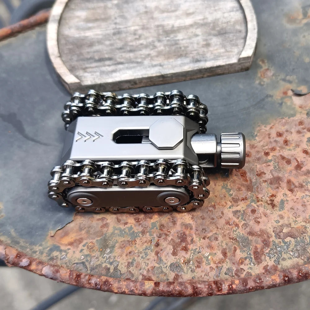 A silver metal tactical tank fidget spinner with a rotating turret resting on a weathered surface.