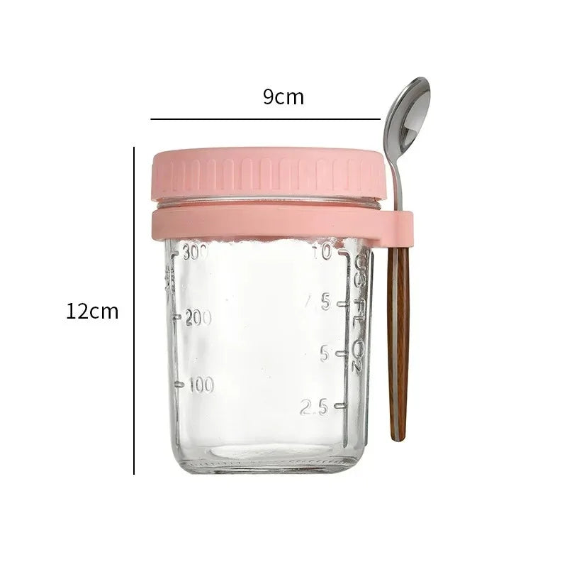 A clear glass jar with a pink lid and a wooden spoon, used for overnight oats or breakfast.